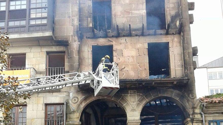 Los bomberos realizan labores de desescombro en el edifico calcinado. // C.G.