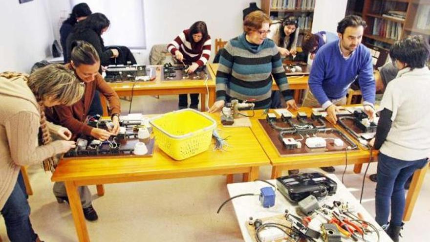 Las alumnas del curso siguen las instrucciones del monitor para reparar averías eléctricas.  // Marta G. Brea