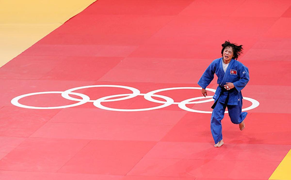 La nord-coreana An Kum Ae corre celebrant la seva medalla d’or en la categoria de -52 quilos de judo després de vèncer la cubana Yanet Bermoy.