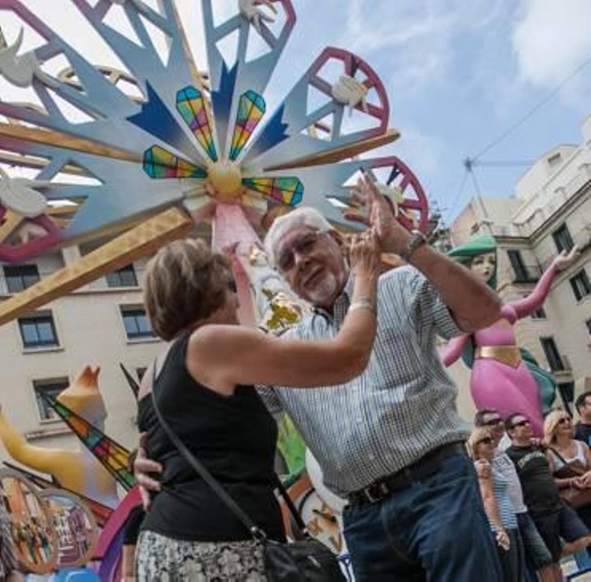 Una pareja baila delante de la Hoguera Oficial, ayer. Será la primera en arder mañana en Alicante.