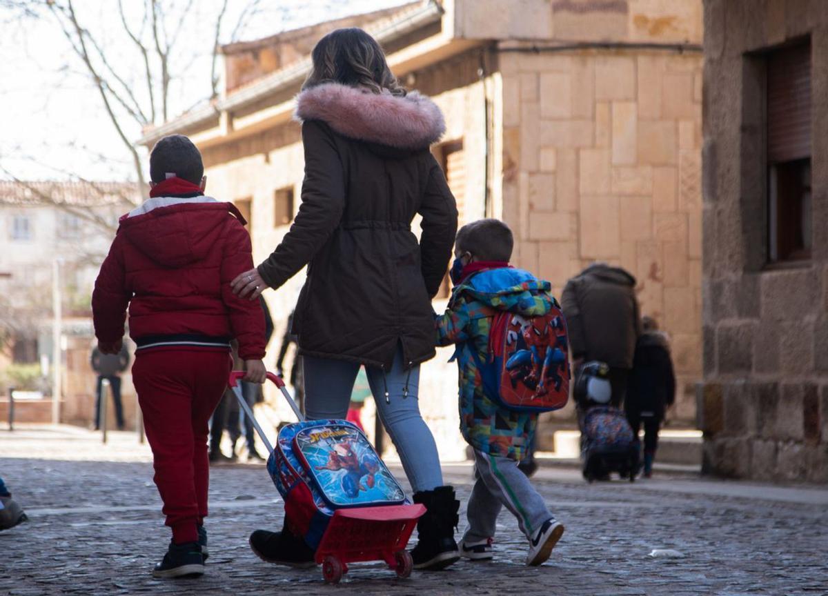 Una madre con sus dos hijos a la salida del colegio. | Emilio Fraile