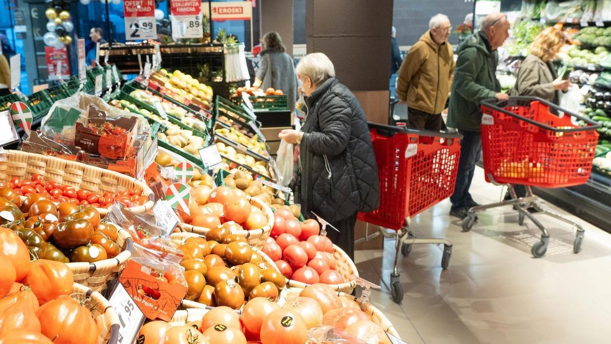Una mujer compra verdura en un supermercado.