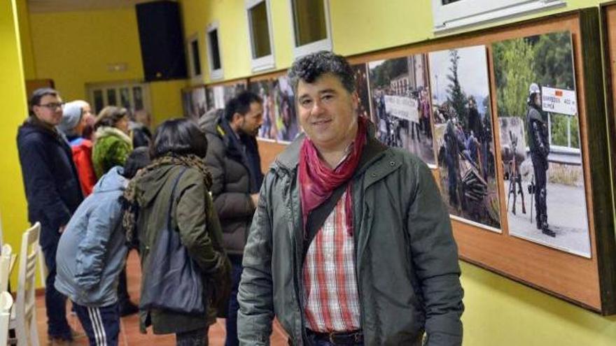 Fernando Rodríguez, ante varias de las fotos de su exposición en Lantero, con visitantes detrás.