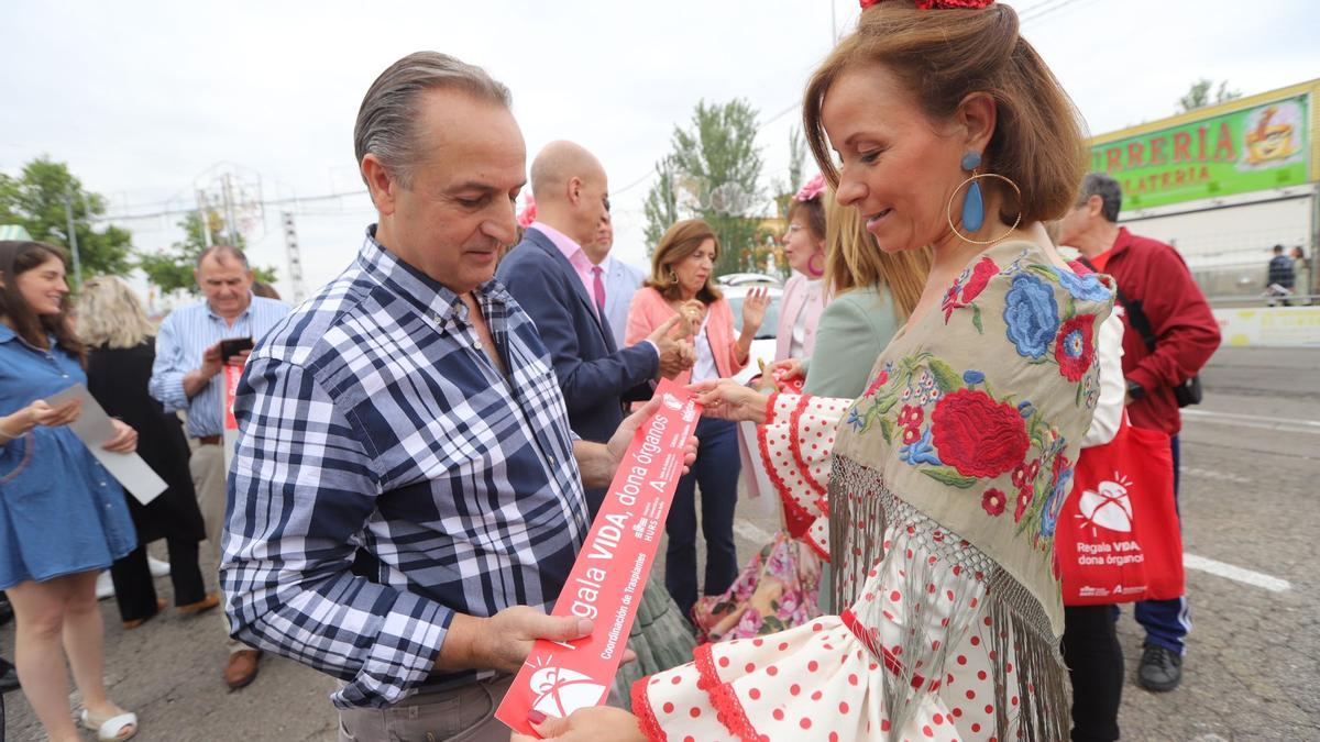 El presidente de Pide Taxi, Miguel Ruano y la directora gerente del Hospital Reina Sofía, Valle García, colocan la pegatina de la campaña de sensibilización.