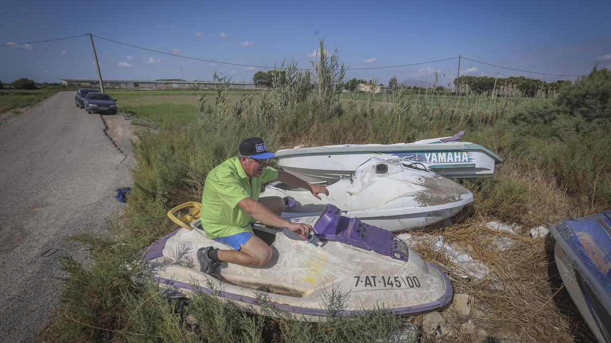 Moisés Cruz bromea sobre una de las motos náuticas abandonadas  en los saladares de Catral