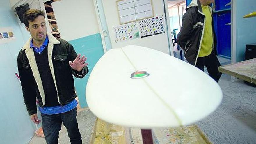 Nacho Agote y Ramón Rodríguez, junto a una de las tablas de surf artesanales.