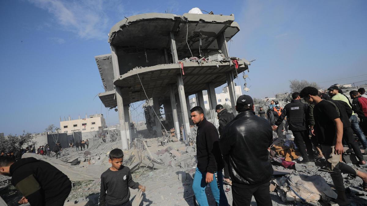 Varias personas junto a un edificio destrozado por losbombardeos de israel en Gaza.