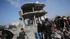 Varias personas junto a un edificio destrozado por losbombardeos de israel en Gaza.