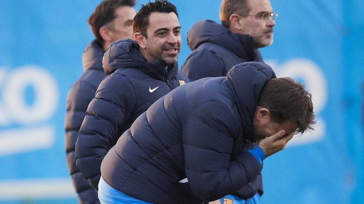 Xavi bromea con uno de sus ayudantes durante un entrenamiento