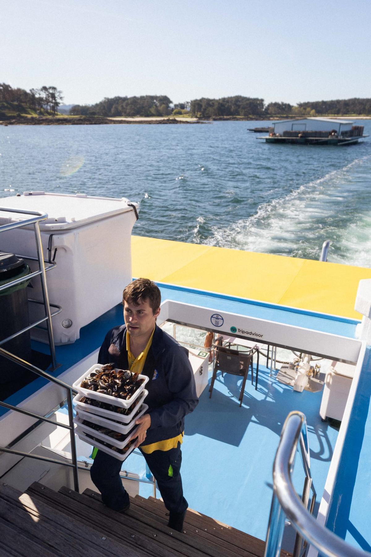 Uno de los trabajadores de Cruceros do Ulla repartiendo mejillones.