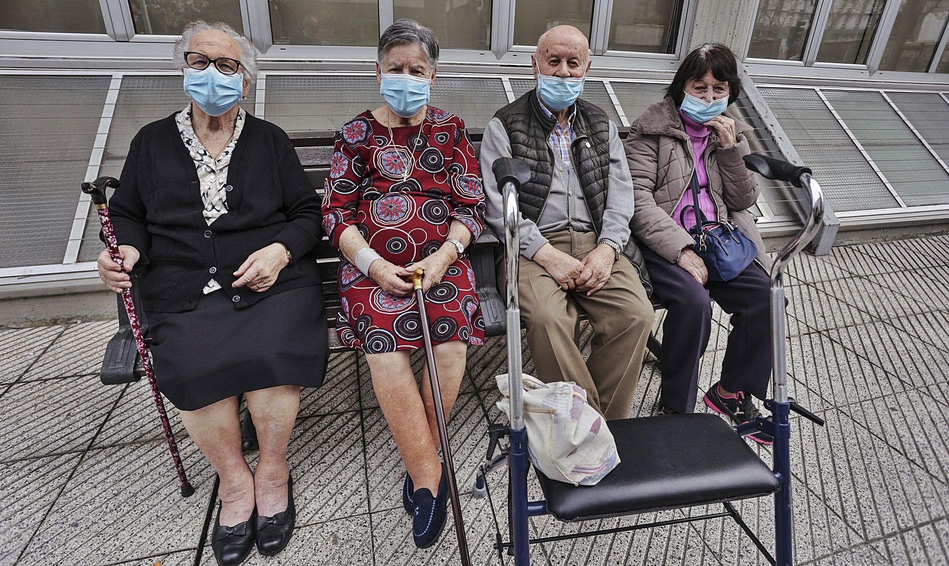 María Cienfuegos, Damiana Robles, Manuel Cordera y María Pilar López, sentados a la puerta del geriátrico Santa Teresa de Oviedo