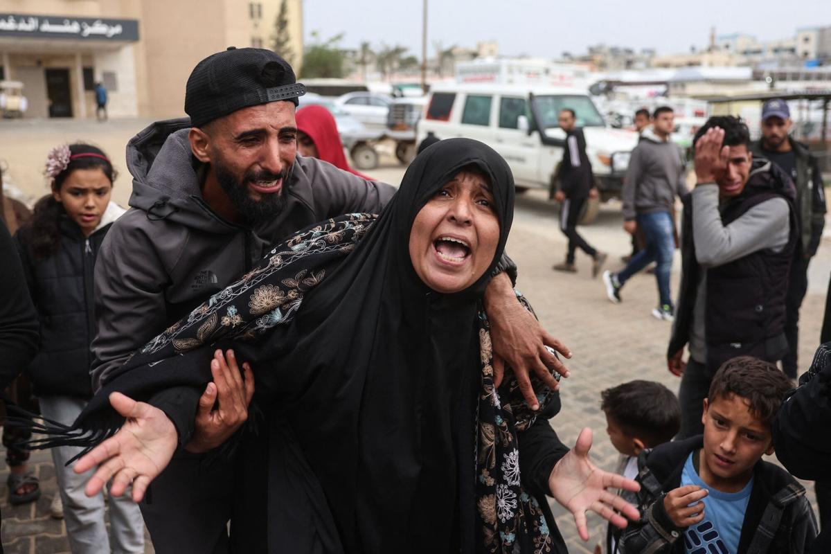 Varias personas lloran la muerte de un familiar durante los ataques de Israel.