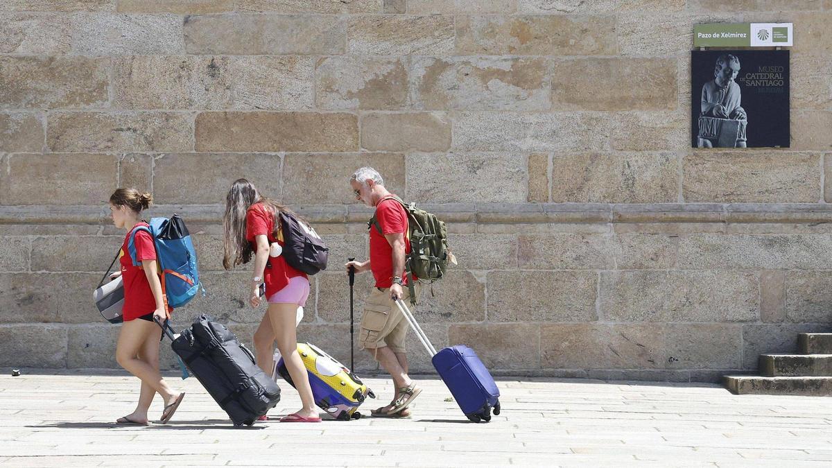 Turistas en Santiago cargando con sus maletas en la plaza del Obradoiro