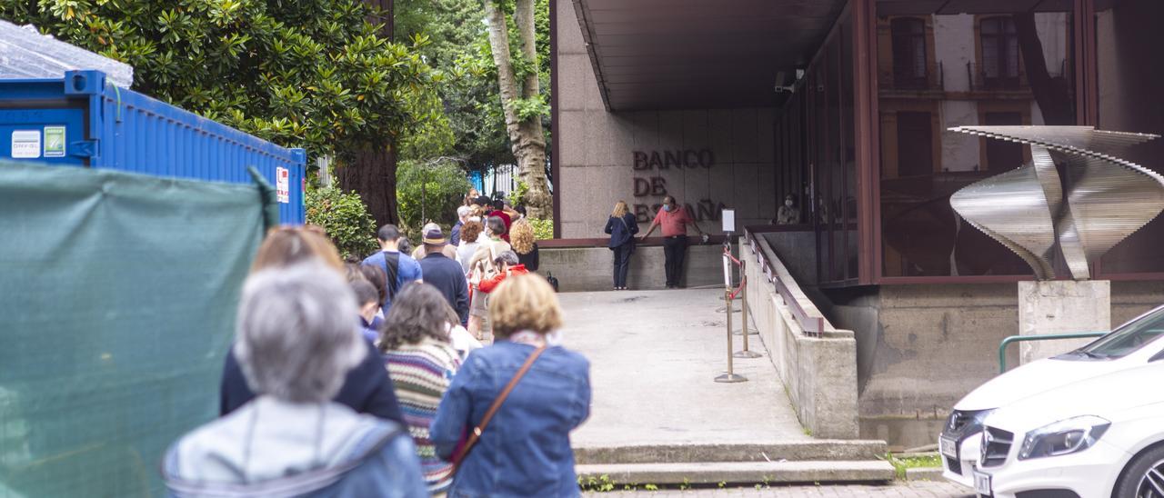 Decenas de personas hacen cola ante la sede ovetense del Banco de España.