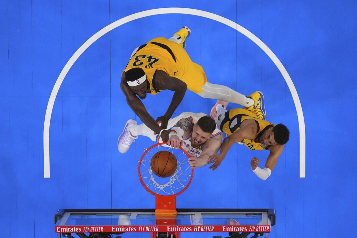 Oklahoma City Thunder center Isaiah Hartenstein, center, shoots against Indiana Pacers forward Pascal Siakam (43) and guard Tyrese Haliburton, right, during the second half in Game 1 of the NBA Finals basketball series Friday, June 6, 2025, in Oklahoma City. (Julio Cortez/Pool Photo via AP)