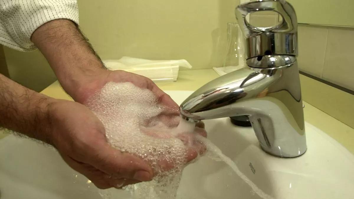 Una persona se lava las manos con agua del grifo.