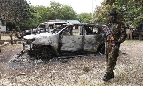 A policeman guards government cars burnt in the recent attack by unidentified gunmen in the coastal Kenyan town of Mpeketoni