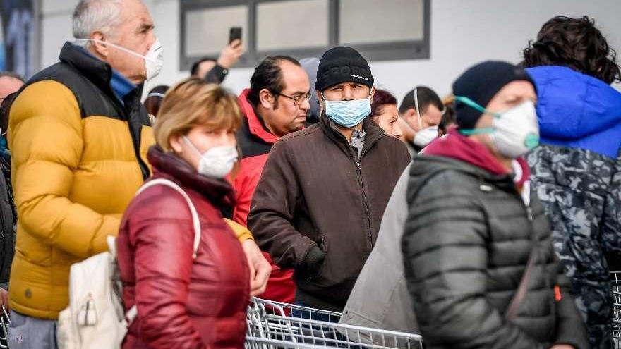 Vecinos de Casalpursterlengo acuden a los supermercados con mascarilla. // Claudio Furlan