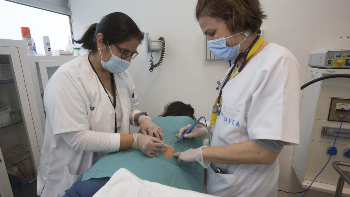 Dos profesionales en una intervención de cirugía menor en un centro de salud de Alicante.