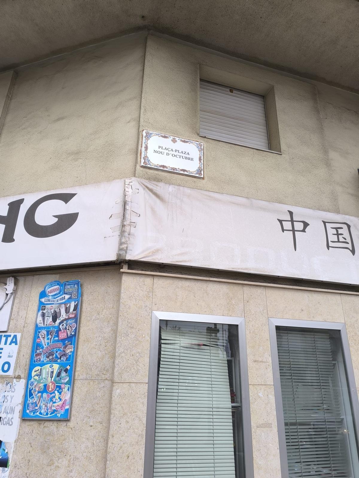 Placa de cerámica que identifica la plaza 'Nou d'Octubre'.