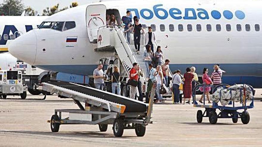 Turistes descendint d´un avió de Pobeda Airlines