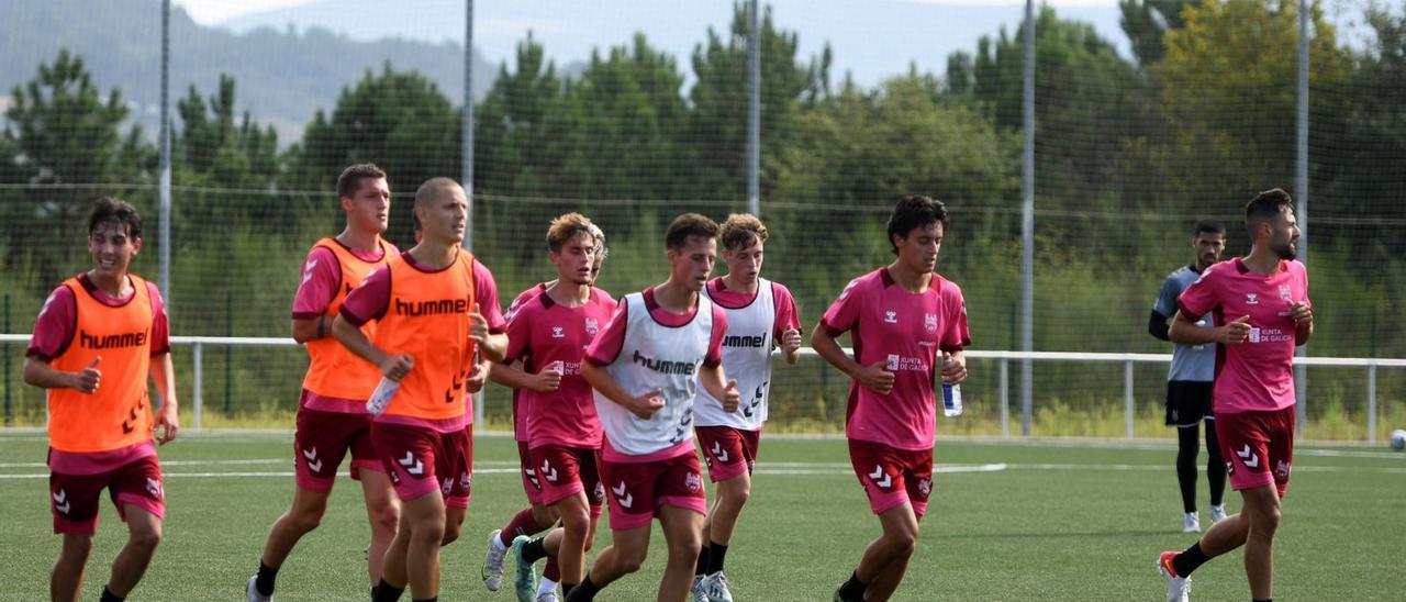 Jugadores del Pontevedra calentando antes de un entrenamiento en el campo de Xeve.