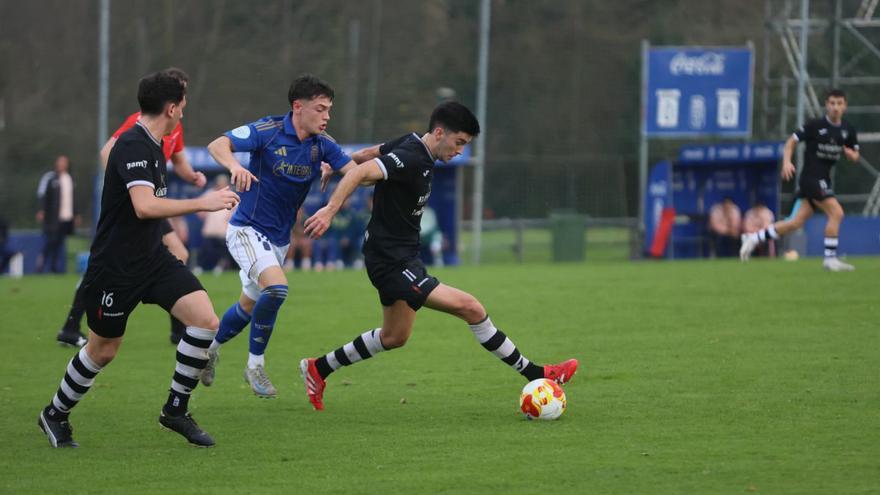 Luisen controlando el balón ante Dieguito, ayer, durante el partido entre el Vetusta-Lealtad en El Requexón. | MARIO CANTELI