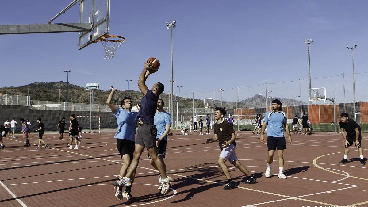 Un grup de joves juguen a bàsquet a les pistes esportives de l'UJI.