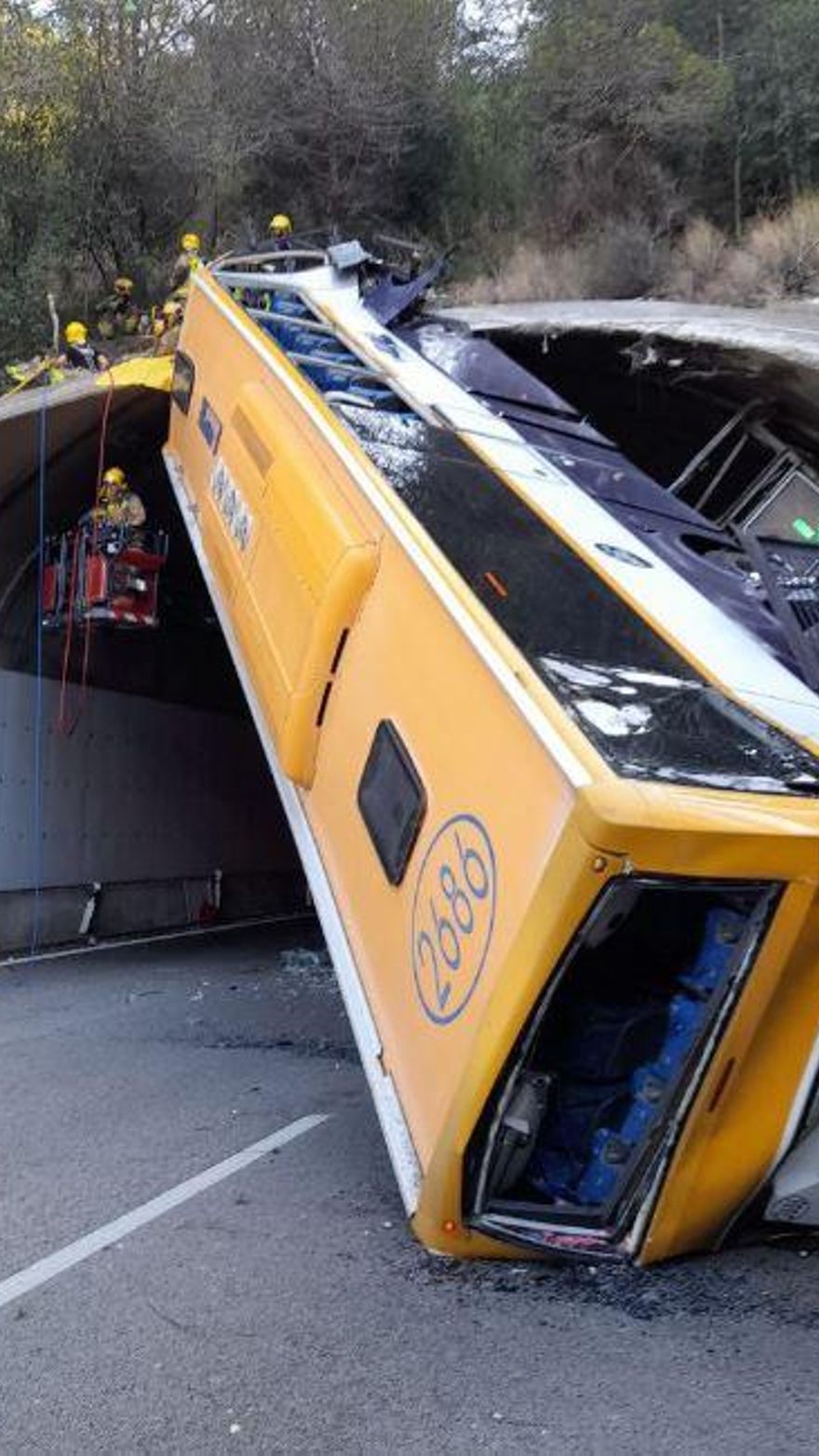 L'autobús bolcat a la C-32, amb els serveis d'emergències treballant al lloc