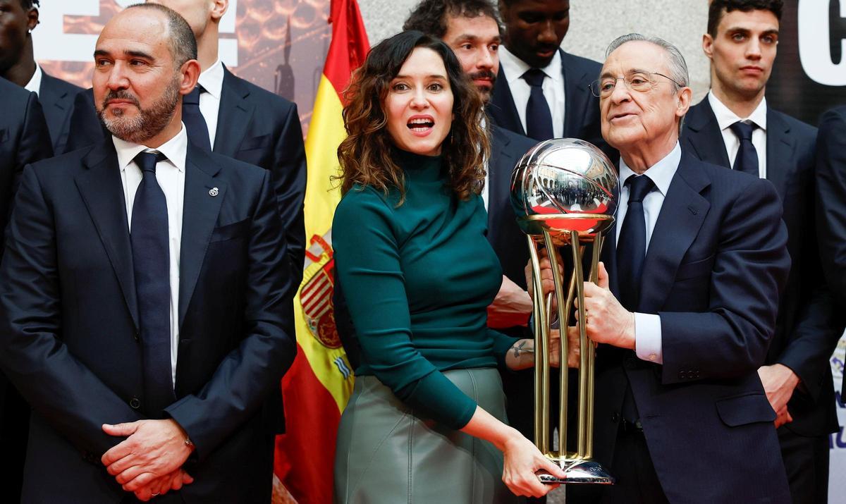 La presidenta Ayuso sujeta la Copa junto a Florentino, y al técnico del Madrid, Chus Mateo