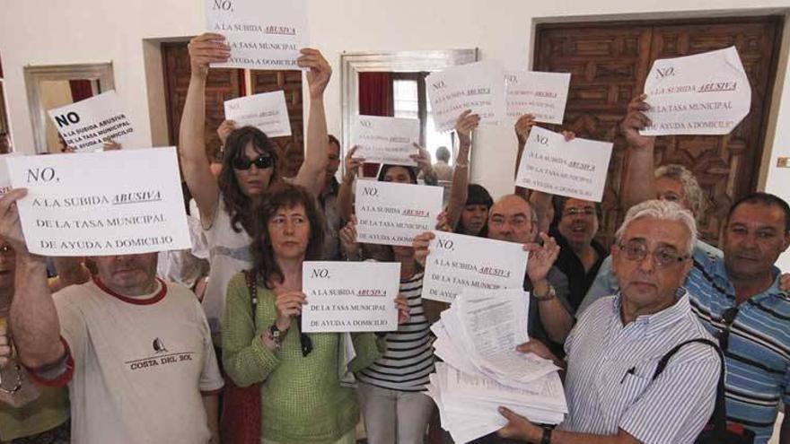 Protestas en el pleno ante el rechazo de suprimir la subida de la ayuda a domicilio en Cáceres