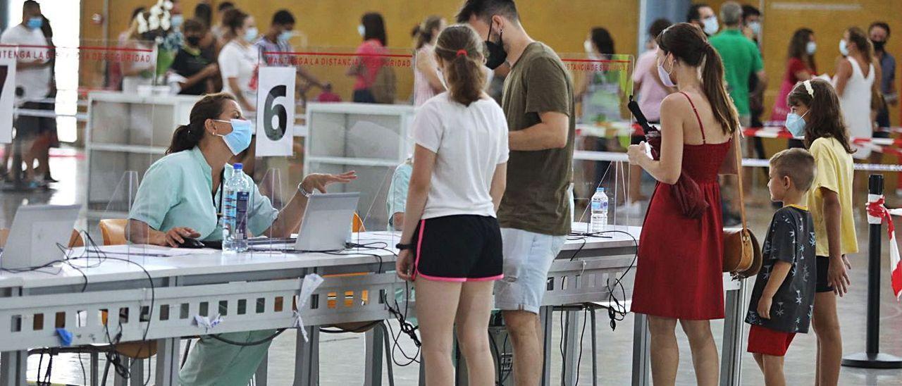 Padres acompañando a sus hijos antes de vacunarse, este martes en IFA, en Elche.