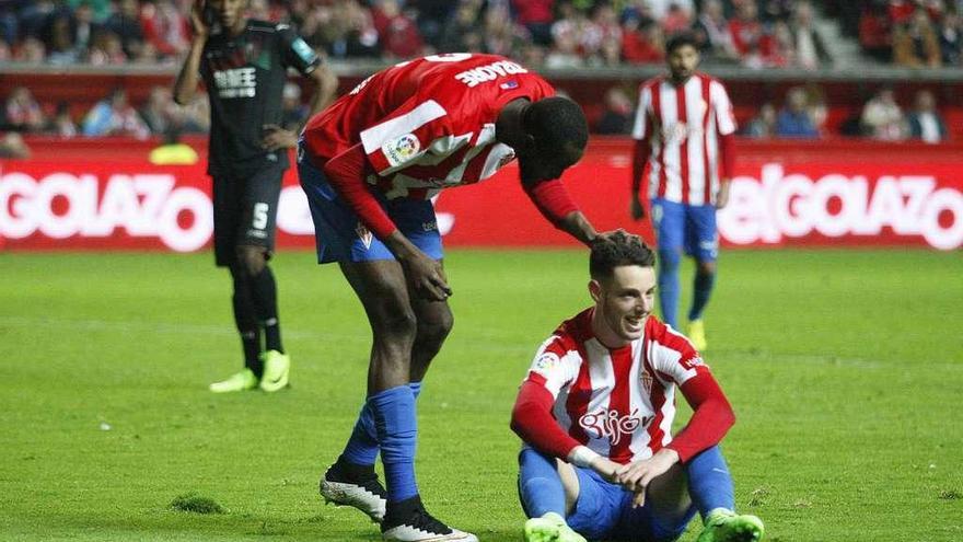 Traoré felicita a Burgui, sentado en el suelo.