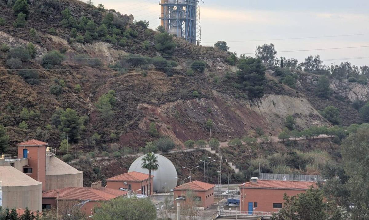 La EDAR del Peñón del Cuervo, en primer plano y detrás, la chimenea de la Fábrica de Cemento de La Araña, desde Atalaya de Jarazmín. | LA OPINIÓN