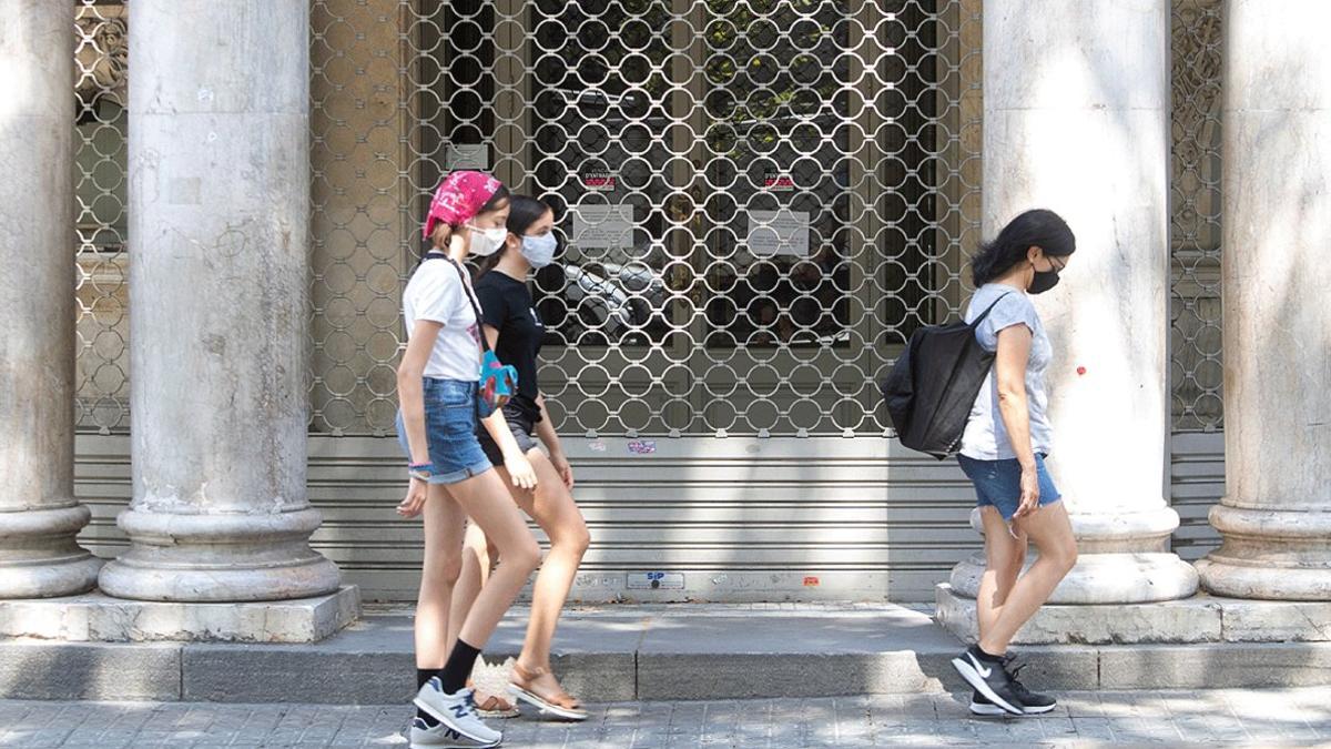 Un grupo de jóvenes pasan por delante del Teatre Coliseum de Barcelona, nuevamente cerrado por los rebrotes de coronavirus, el lunes 27 de julio