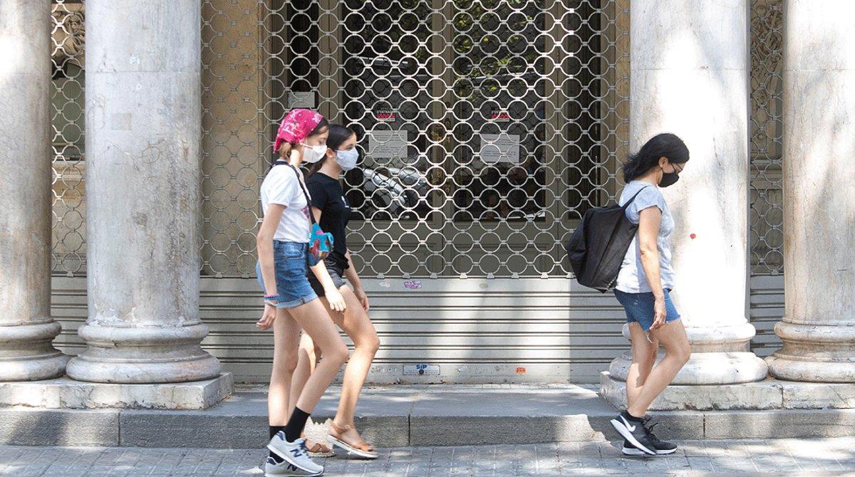 Un grupo de jóvenes pasan por delante del Teatre Coliseum de Barcelona, nuevamente cerrado por los rebrotes de coronavirus, el lunes 27 de julio.