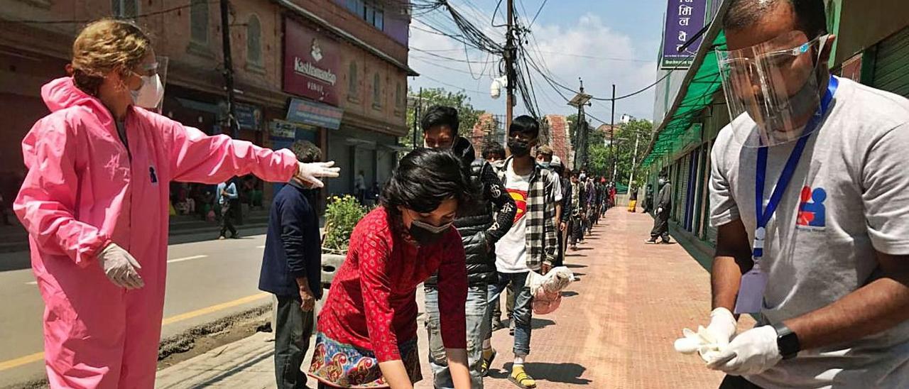 La mallorquina Maria Vives organiza la cola en el reparto de comida en Katmandú.