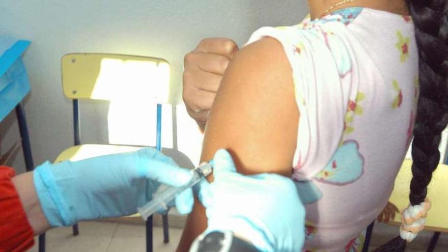 Una sanitaria vacuna a una niña.