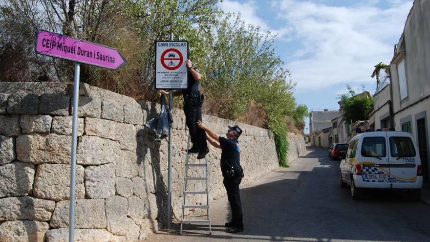 Dos agentes de la Policía Local descubren ayer las señales que restringen la circulación.