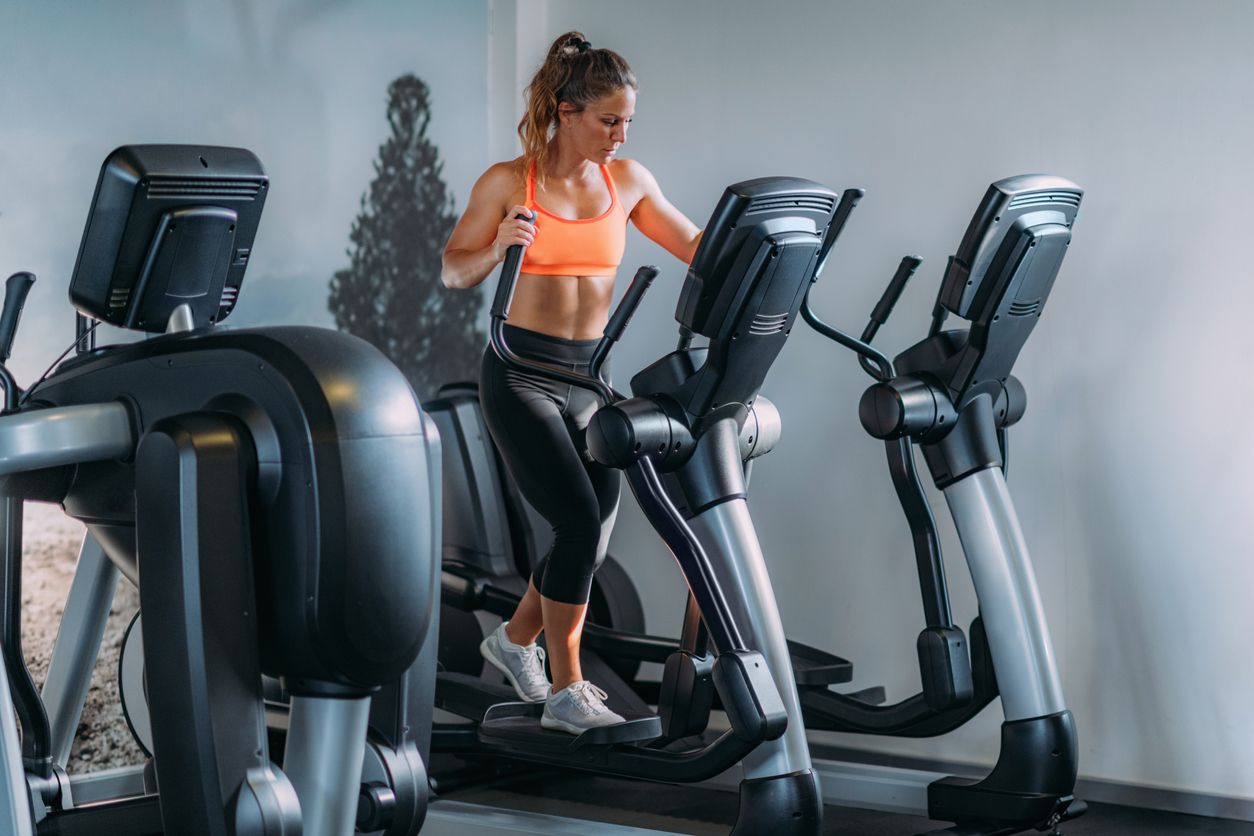 Mujer practicando elíptica en un gym