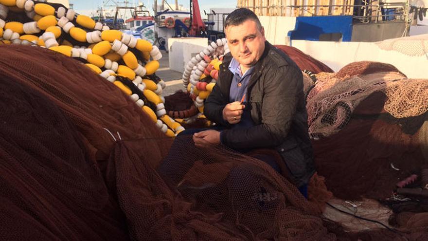 Manuel Haro, en la zona del muelle de La Bajadilla en la que atraca su barco, remienda las artes con las que faena.