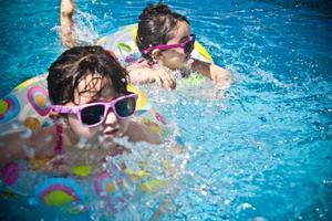 Niños bañándose en una piscina. 