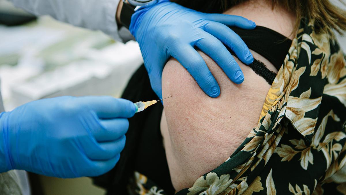 Una mujer recibe una vacuna frente al COVID.