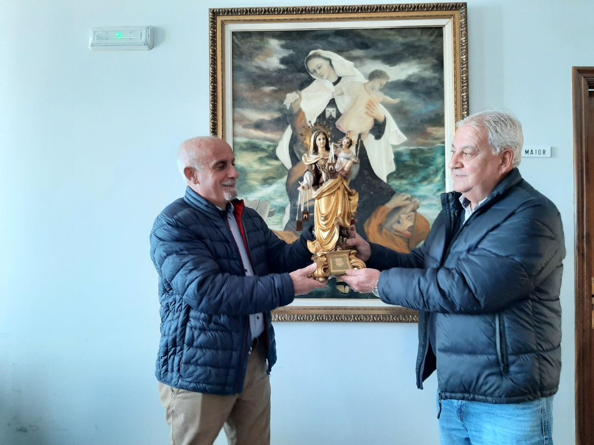 Juan Veiga entrega al patrón mayor de Bueu, José Manuel Rosas, una imagen de la Virgen del Carmen que se estrenará en la procesión de este año.