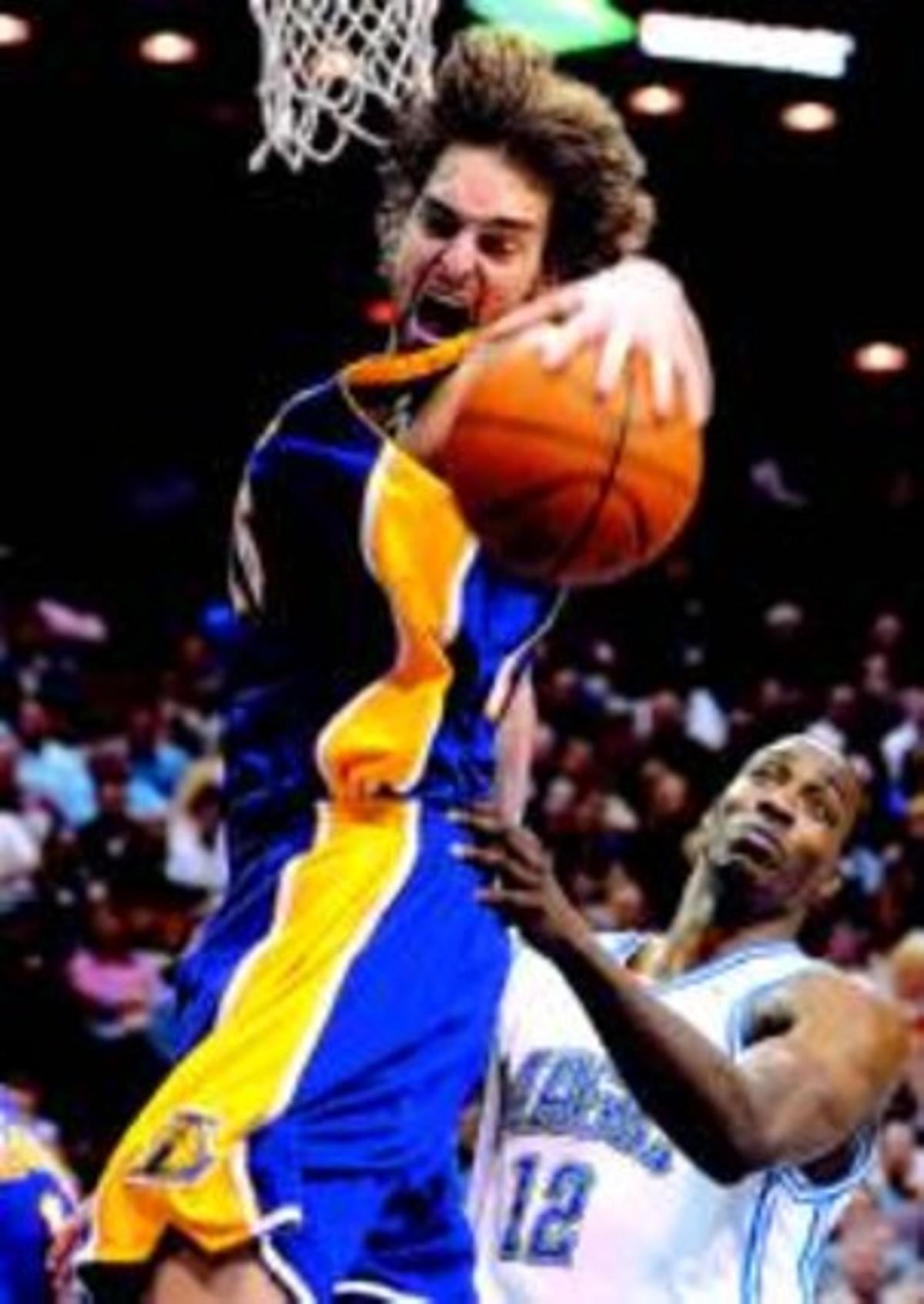 Pau Gasol agafa un rebot davant Dwight Howard. Pau Gasol agafa un rebot davant Dwight Howard.