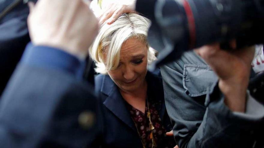Le Pen se protege del lanzamiento de huevos por los empleados de una empresa de transporte. // Reuteres