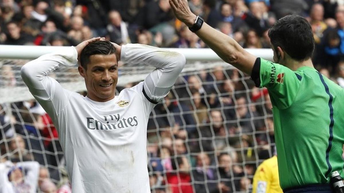 Cristiano Ronaldo sonríe irónicamente ante Undiano Mallenco durante el Real Madrid-Sporting.