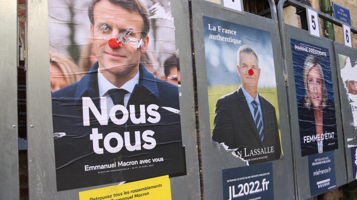 El candidat i actual president Emmanuel Macron amb un nas de pallasso i la candidata Marine Le Pen en uns cartells electorals