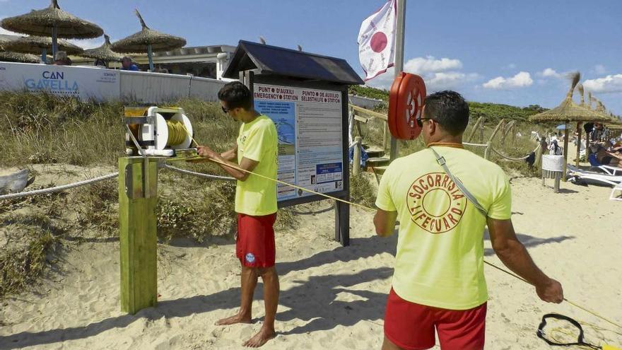 Dos socorristas prueban uno de los carretes de rescate instalados en las playas de Muro.