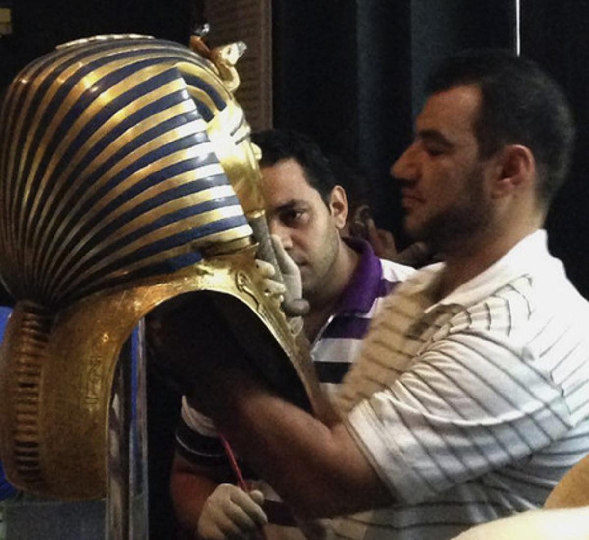 Un restaurador enganxa la barba de la màscara de Tutankamon, el 12 d’agost del 2014.
